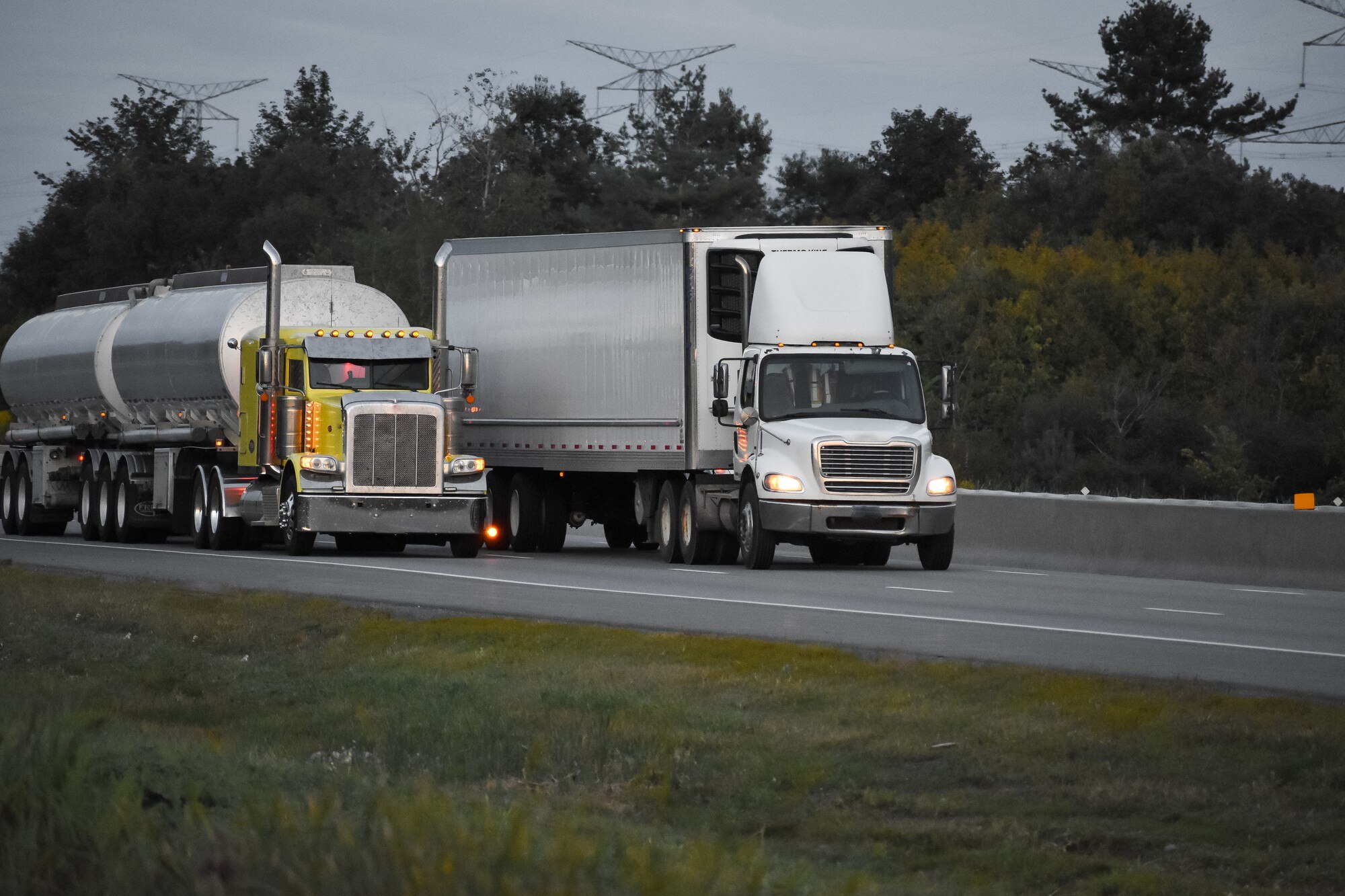 trailer trucks driving road surrounded by beautiful green trees_181624 10810
